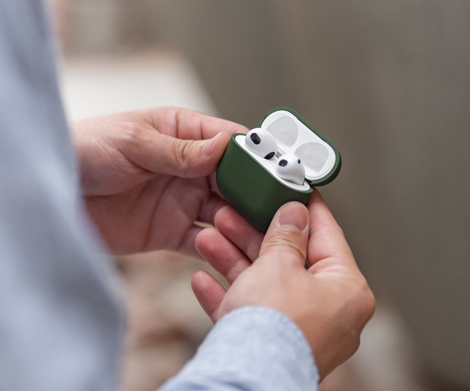 man golding a premium airpods 3 case in green
