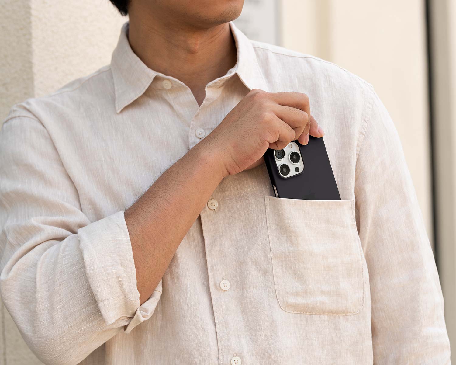 a man pulling a thin iPhone 15 Pro case from his chest pocket