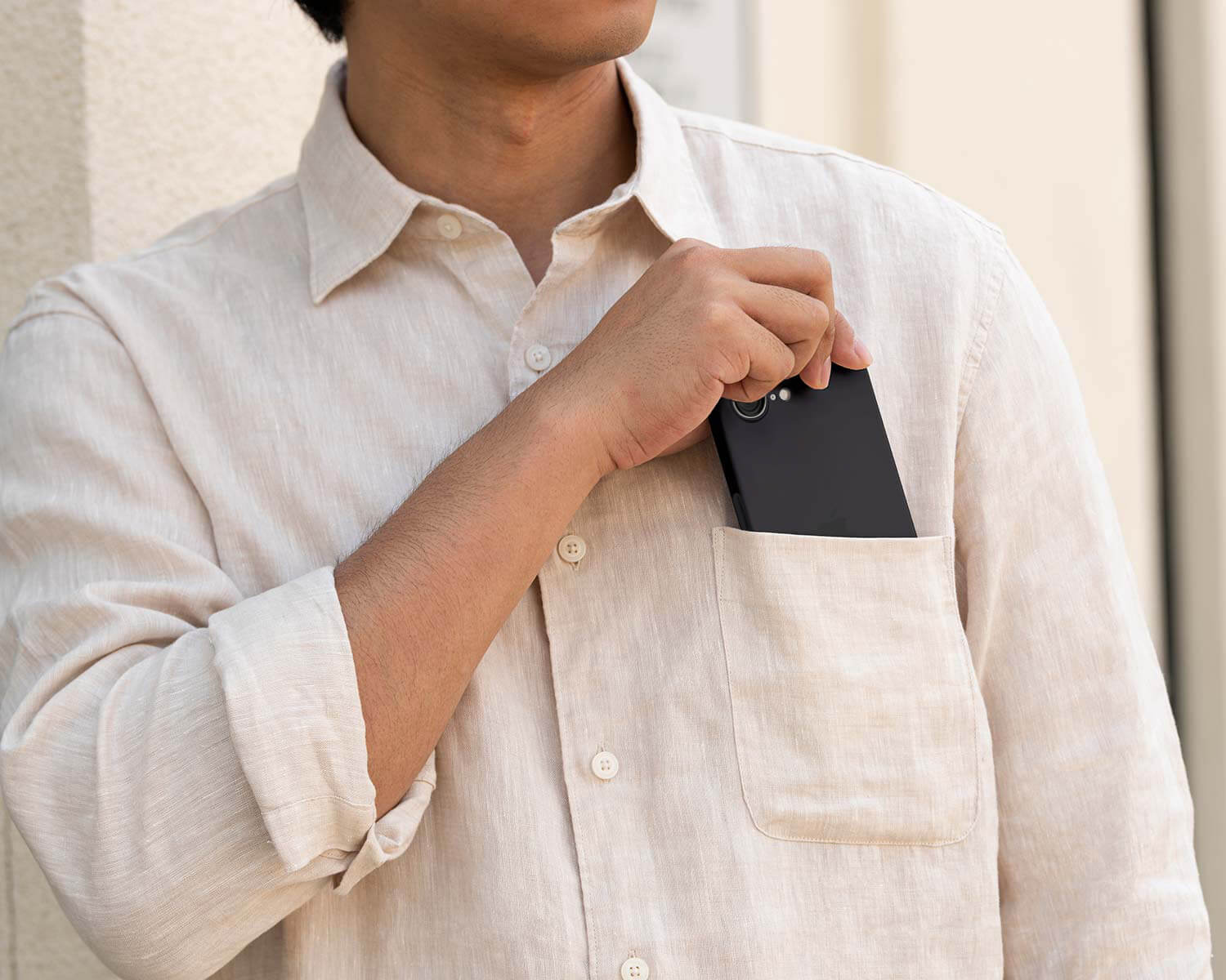 man pulling an iPhone 16e case out of his chest pocket