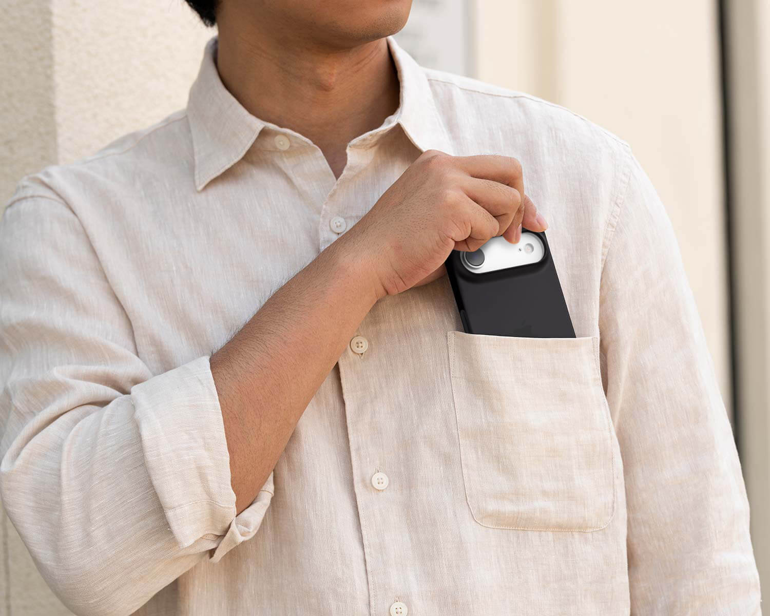 Person wearing a light-colored shirt with a small device attached to their chest.
